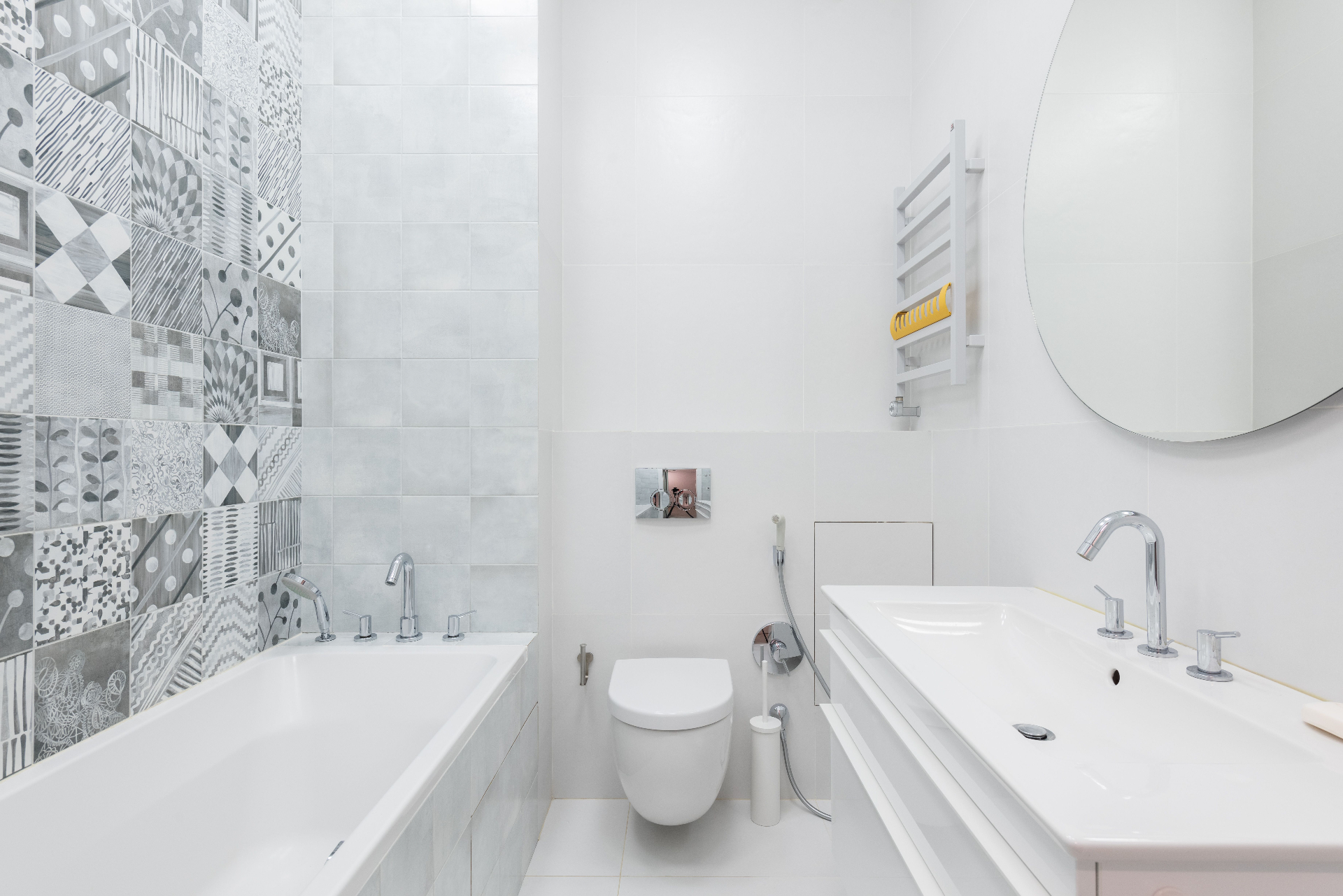 Bright bathroom with patterned feature tiles, bath, vanity and wall-hung toilet